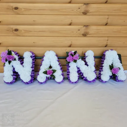 **NANA Artificial Silk Funeral Flowers – Custom 4-Letter Name Tribute Wreath** Honor the memory of a beloved family member with the **NANA Artificial Silk Funeral Tribute Wreath**, designed to commemorate anyone with a **4-letter name**. Whether it’s **NANA**, **MAMA**, **PAPA**, or any other 4-letter name, this elegant wreath offers a personal and lasting tribute. Crafted from high-quality artificial silk flowers, this wreath is ideal for graveside memorials or ceremonies, serving as a beautiful and respectful expression of love and remembrance. --- ### **Key Features:** #### **Customizable 4-Letter Name Tribute** - Personalize your wreath with any **4-letter name** such as **NANA**, **MAMA**, **PAPA**, or **DADA**. - Each letter is carefully crafted from premium **artificial silk carnations**, ensuring a vibrant and lifelike display. #### **Premium Quality Materials** - Made with high-quality **artificial silk flowers** that retain their beauty and freshness, even over time. - Finished with **ribbon edging** and optional **posy clusters**, adding sophistication and elegance to your memorial wreath. #### **Wide Selection of Color Options** - Choose from **8 beautiful carnation colors** including White, Red, Pink, Yellow, Purple, and more. - Select from **14 ribbon colors**, such as Baby Pink, Gold, Navy, Burgundy, Silver, and more, for a unique and personalized look. - Optional **posy clusters** available in contrasting or complementary colors to enhance your tribute. #### **Ideal Size for Memorial Display** - The wreath is designed to create a striking, yet respectful tribute, measuring **XX inches wide x XX inches high**. - Supplied with a **florist frame stand** for secure and stable placement at gravesides or memorial services. #### **Free Personalized Message Card** - Includes a **complimentary message card and holder**, allowing you to include a personal note of remembrance for your loved one. --- ### **How to Personalize Your Tribute:** 1. **Select the Name**: Choose “NANA” or any **4-letter name** for your wreath. 2. **Pick Carnation Colors**: Choose from **8 vibrant carnation colors** such as White, Red, Yellow, Pink, and more. 3. **Choose Ribbon Colors**: Select from **14 ribbon colors** to complement or contrast with the carnation choice. 4. **Add Posy Clusters**: Add optional posy clusters in coordinating or contrasting colors for extra beauty and personalization. 5. **Provide Details**: Use the “Personalization” box to specify the name, carnation color, ribbon color, and posy cluster choices. --- ### **Examples of Custom Designs:** - **Classic Tribute:** Name – NANA Carnations – White Ribbon – Gold Posy – Purple - **Vibrant Memorial:** Name – MAMA Carnations – Red Ribbon – Baby Pink Posy – White - **Soft Remembrance:** Name – PAPA Carnations – Yellow Ribbon – Silver Posy – Blue --- ### **Why Choose This Tribute?** - **Fully Customizable:** Choose colors and personalize the name to create a unique and special tribute. - **Lifelike and Durable:** Premium silk flowers ensure the wreath remains beautiful and vibrant for years to come. - **Timeless and Elegant Design:** A meaningful and respectful way to celebrate and remember your loved one. --- ### **Important Notes:** - **Color Variations:** Slight differences in flower and ribbon shades may occur due to lighting conditions during photography. - **Floral Substitutions:** Occasionally, substitutions may be necessary for flower or posy styles to maintain design integrity and quality. --- ### **A Beautiful and Lasting Tribute** The **NANA Artificial Silk Funeral Flowers Tribute Wreath** is a thoughtful and meaningful way to honor a loved one’s life. Whether commemorating **NANA**, **MAMA**, **PAPA**, or any 4-letter name, this customizable wreath offers a heartfelt, lasting expression of love and remembrance.